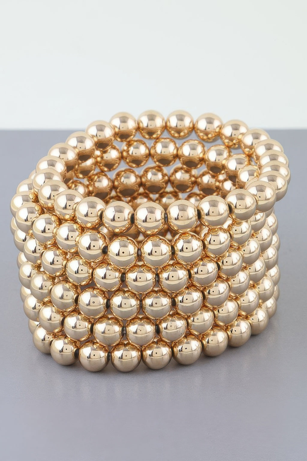 Gold tone multi-row beaded cuff bracelet with rounded bead pattern