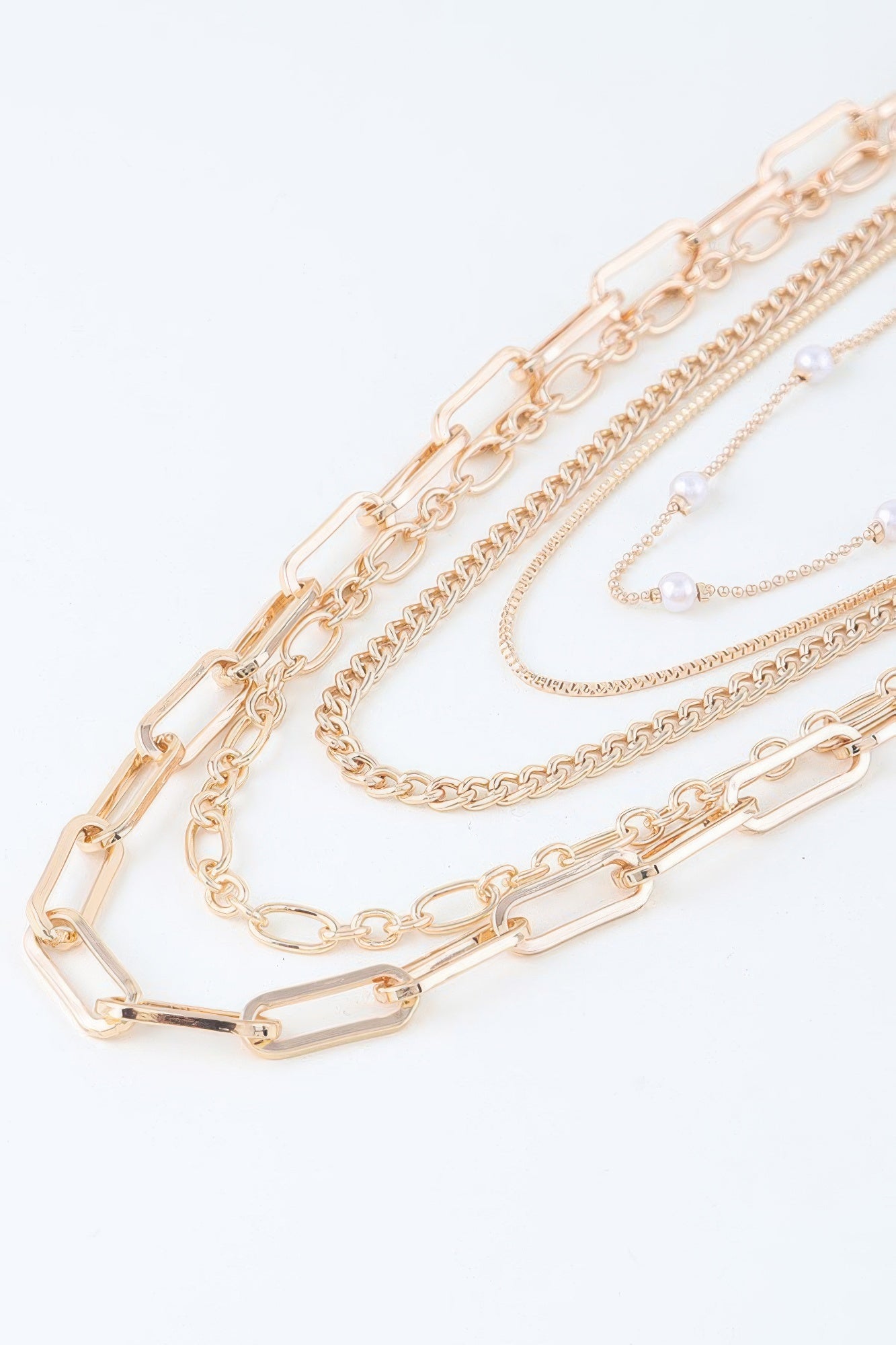 Close-up gold-tone chain drop necklace with rectangular links and dangling pearl beads