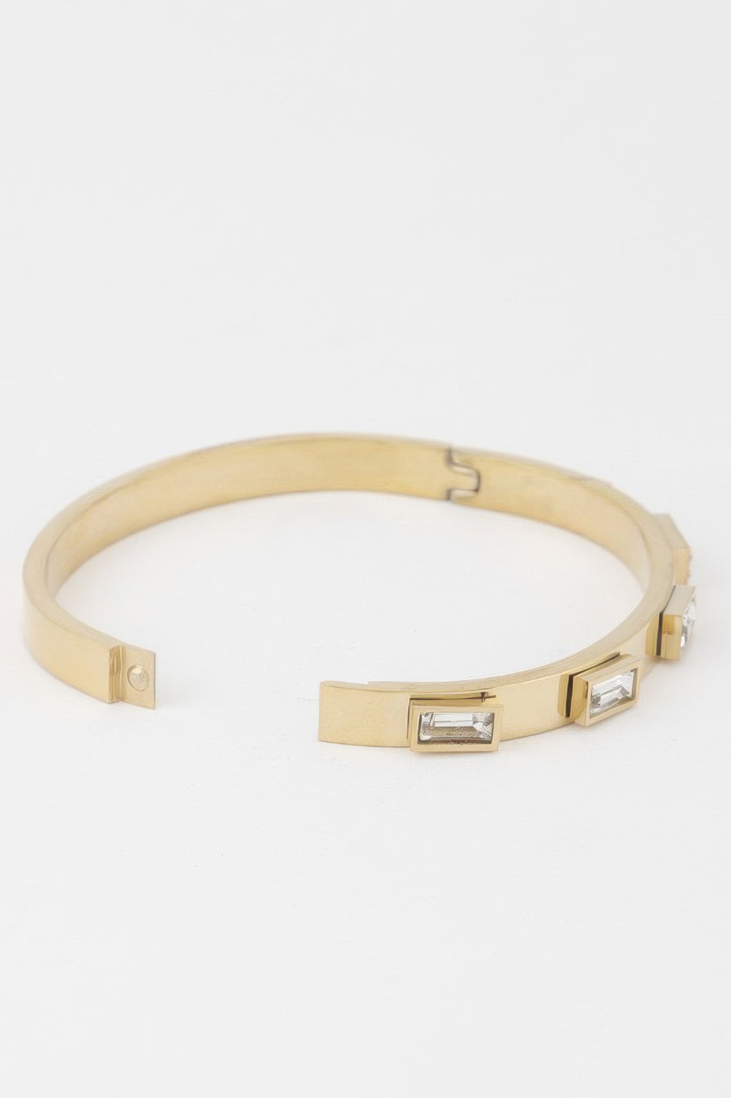 Gold bracelet with hinged clasp and two clear rectangular crystals