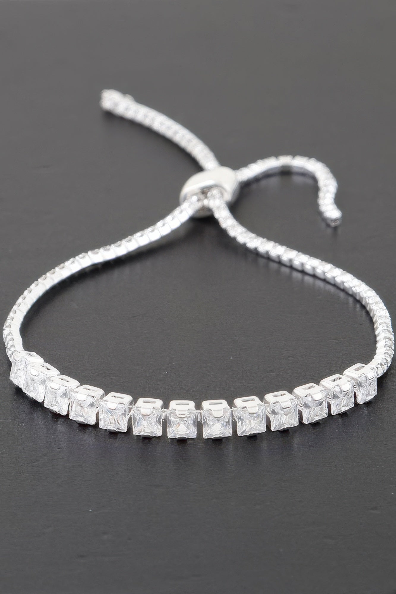 Silver-toned tennis bracelet with clear square cubic stones and a small open-link clasp