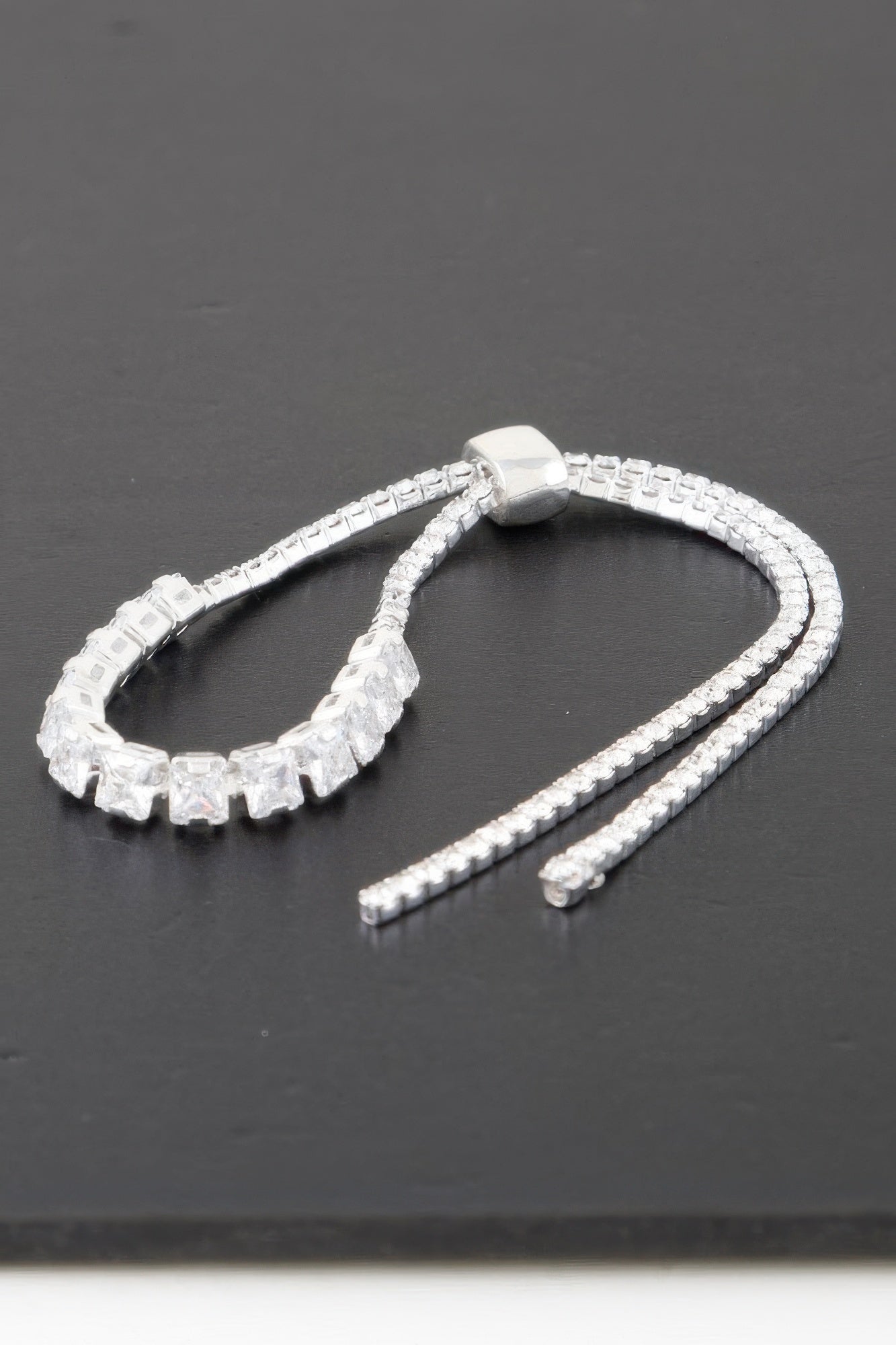 Silver-toned cubic-stone bracelet with clear square links and a single connector bead