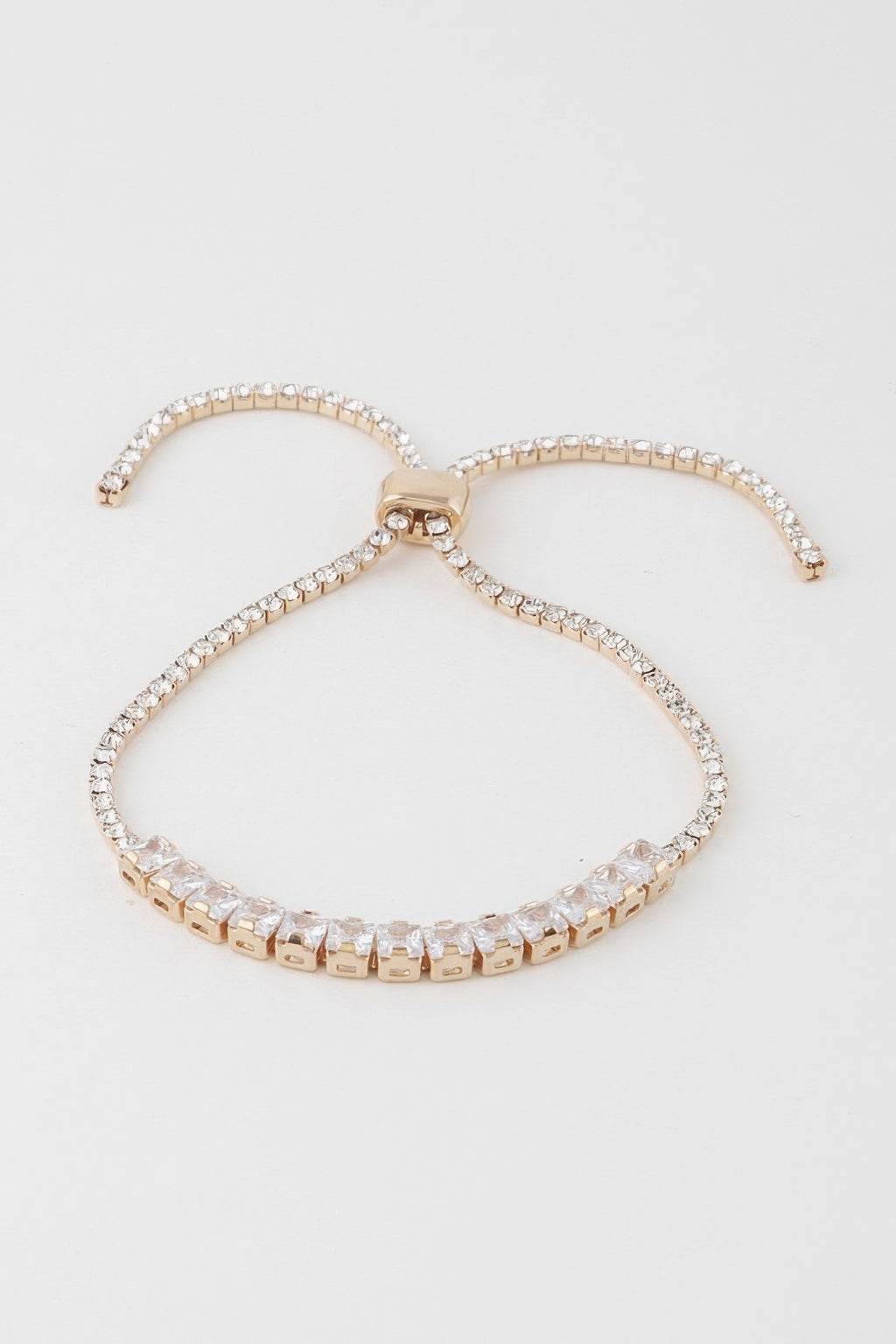 Gold-toned bracelet with clear square cubic stones and a bow-shaped center clasp