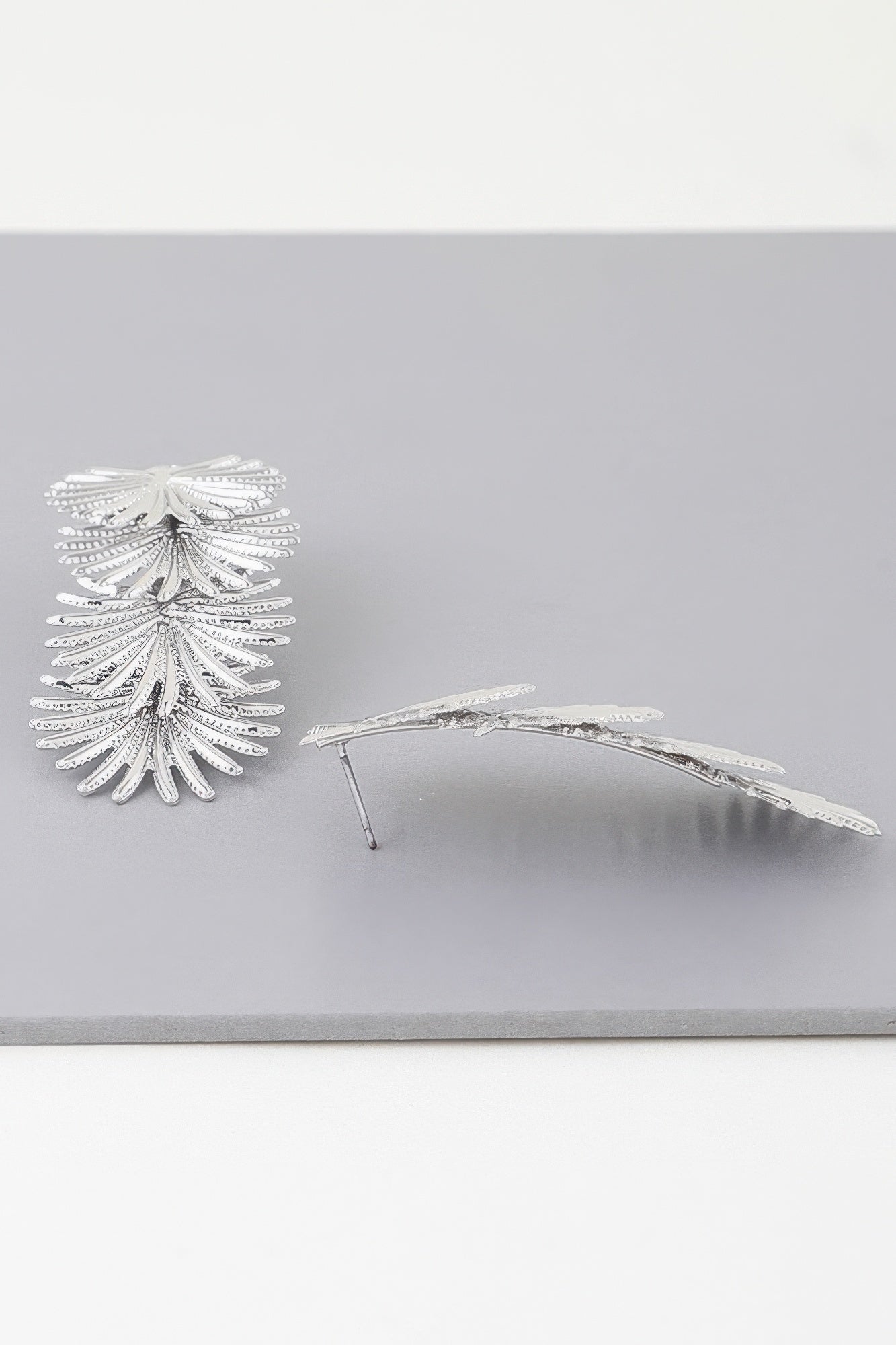 Silver multi-flare leaf drop earrings, side view with curved bar and layered leaves
