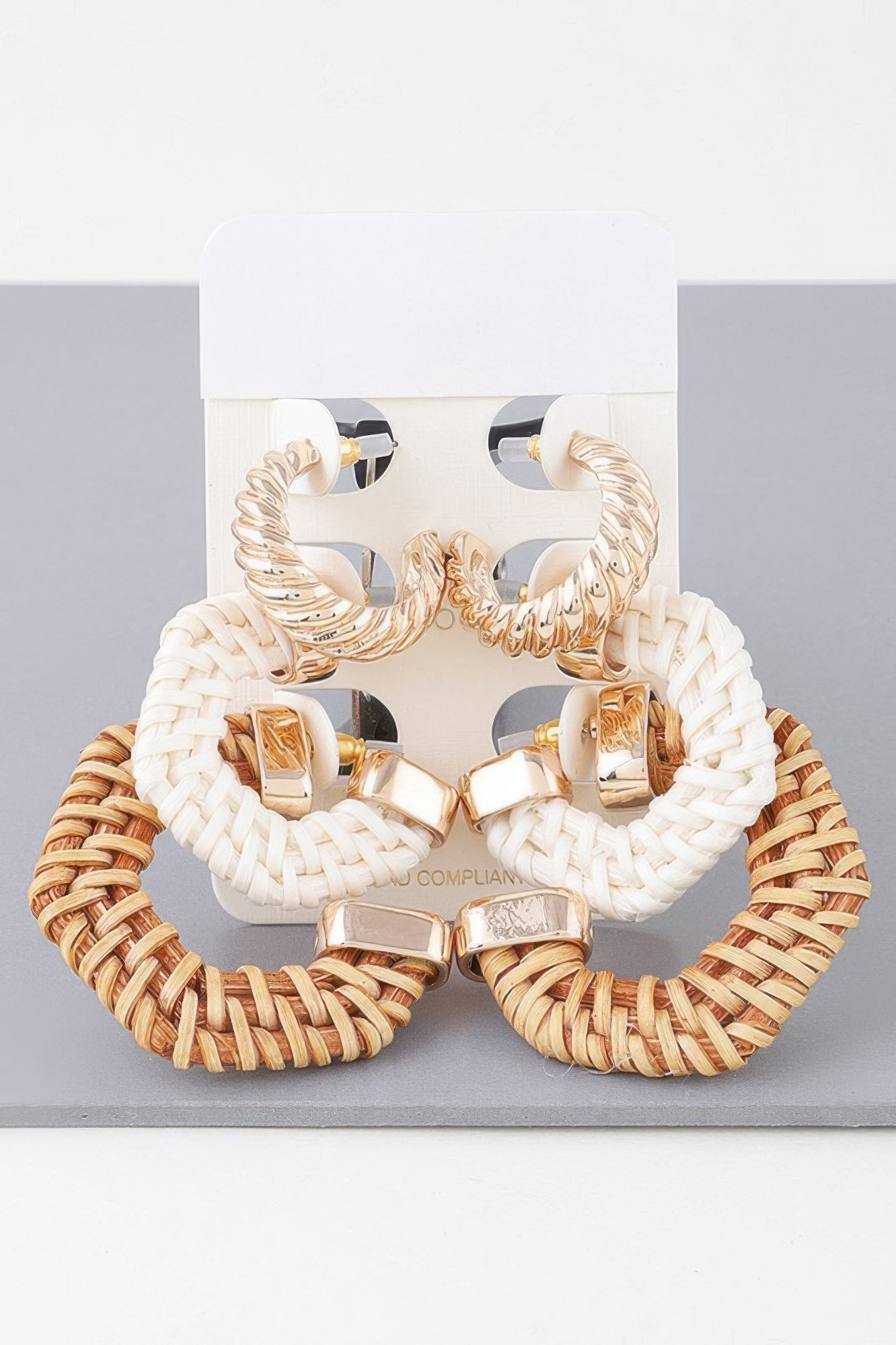 Natural multi woven hoop earrings set with gold-tone geometric stud ends, pair shown