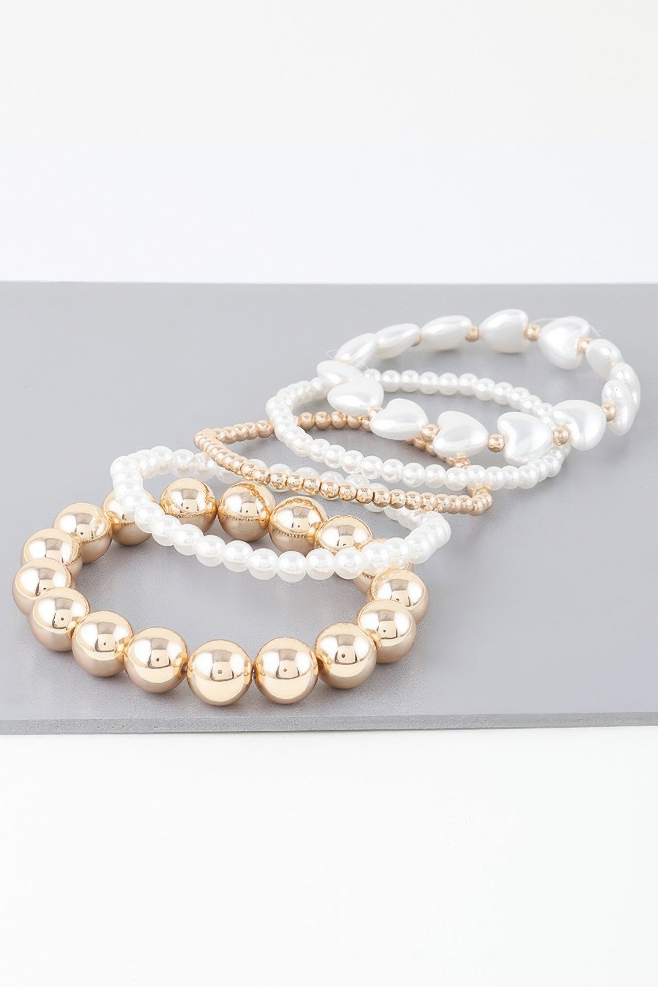 Multi-strand bracelet: white pearl beads with gold round accents and hearts
