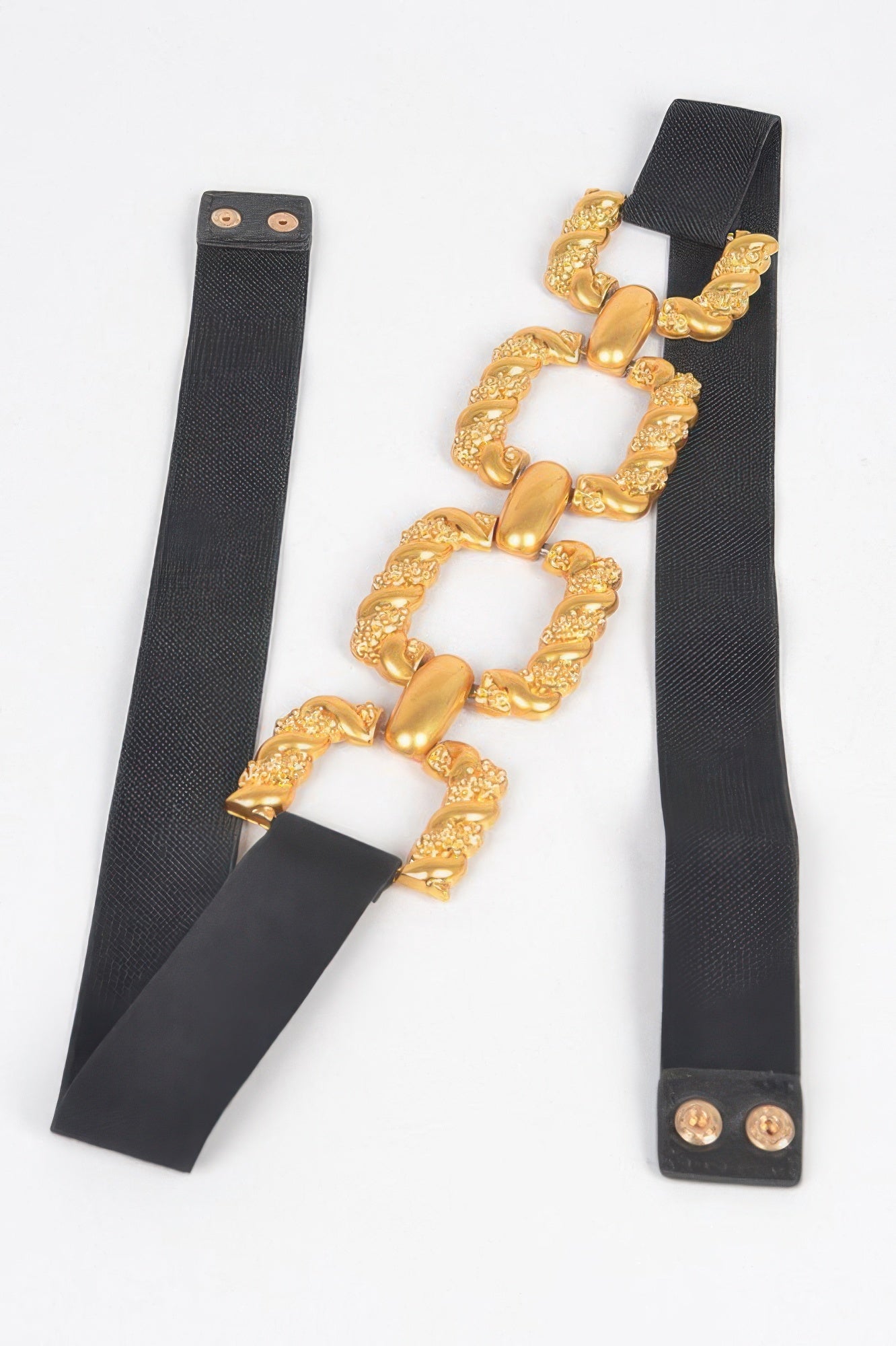 Black elastic belt strap with gold ornate buckle segments and snap ends