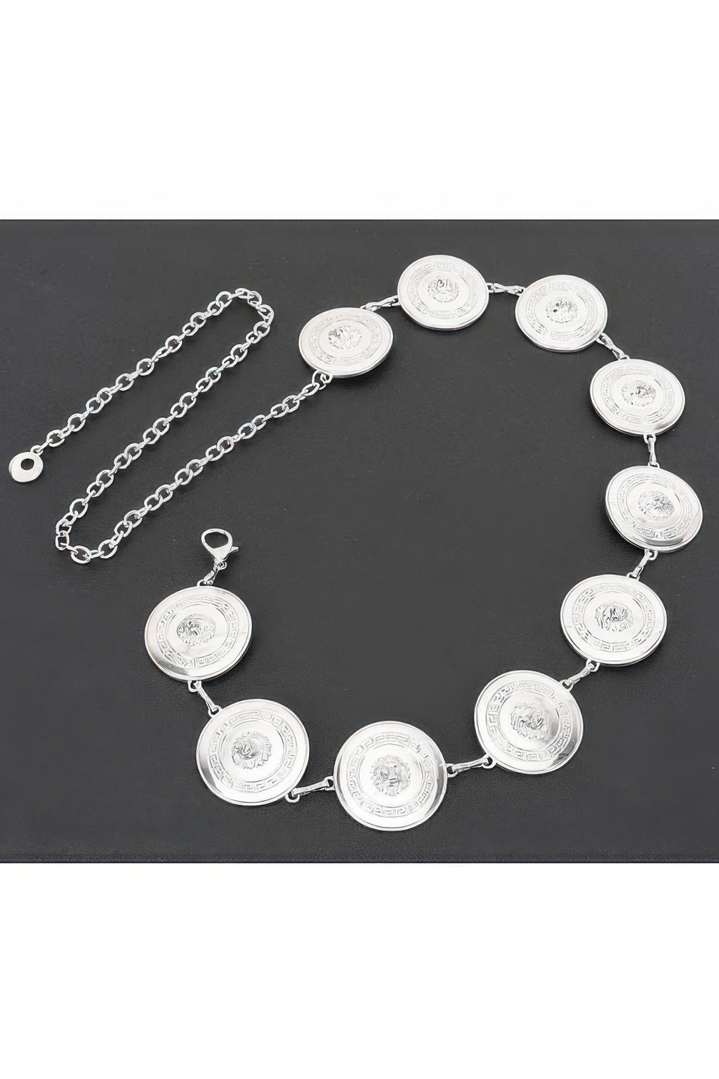 Silver round coin chain belt with linked medallions, flat lay