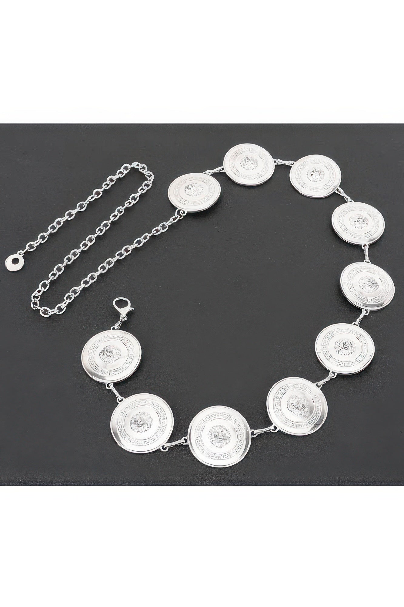 Silver round coin chain belt with linked medallions, flat lay
