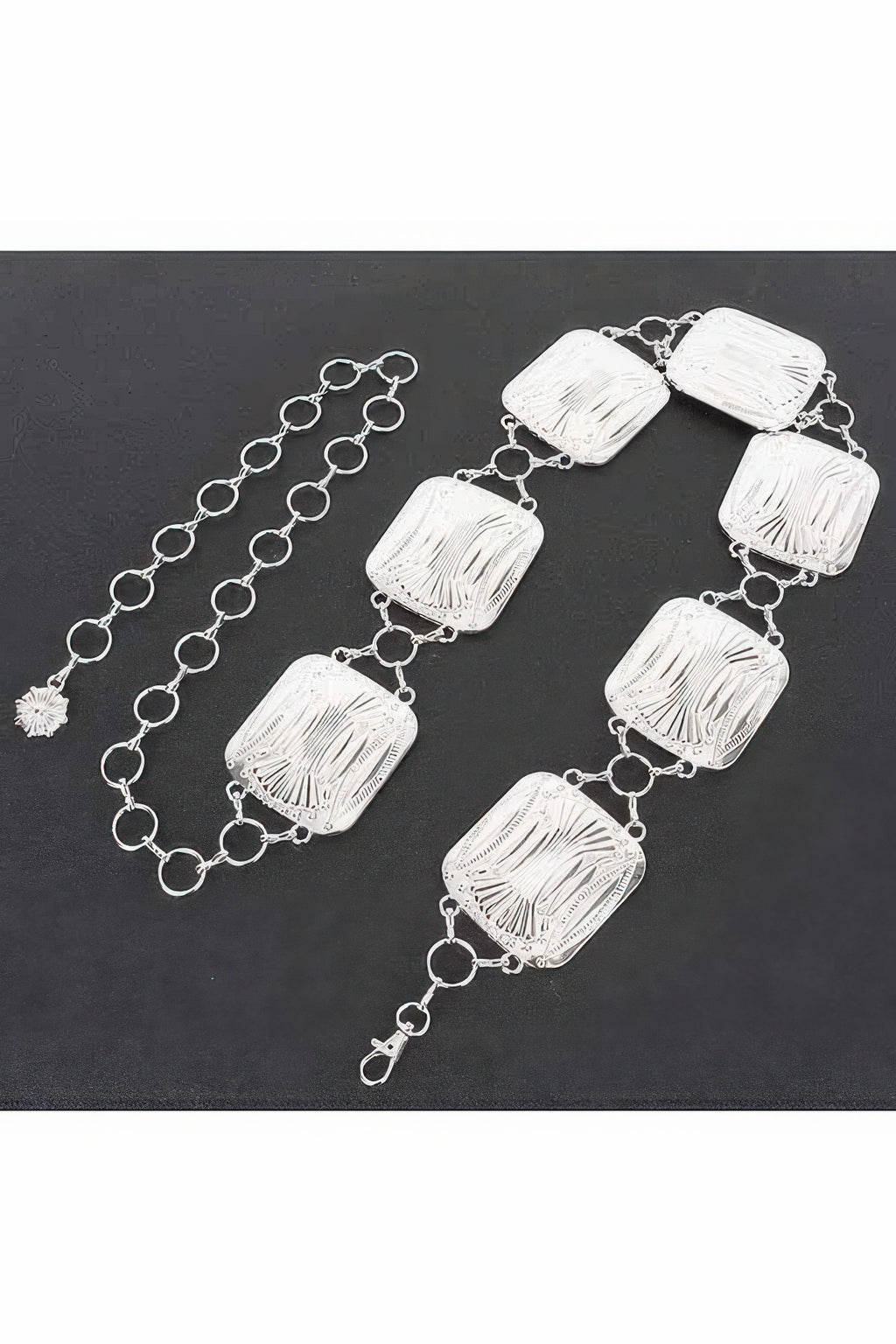 Silver chain belt laid flat with engraved square links and clasp ends