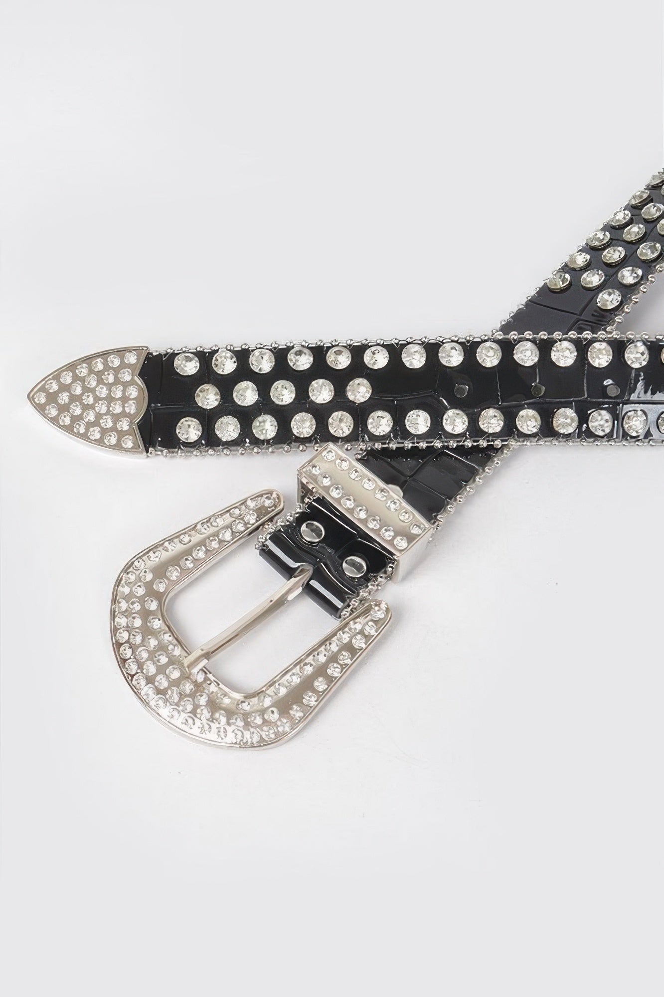 Close-up of black belt strap with silver studs and ornate oval buckle