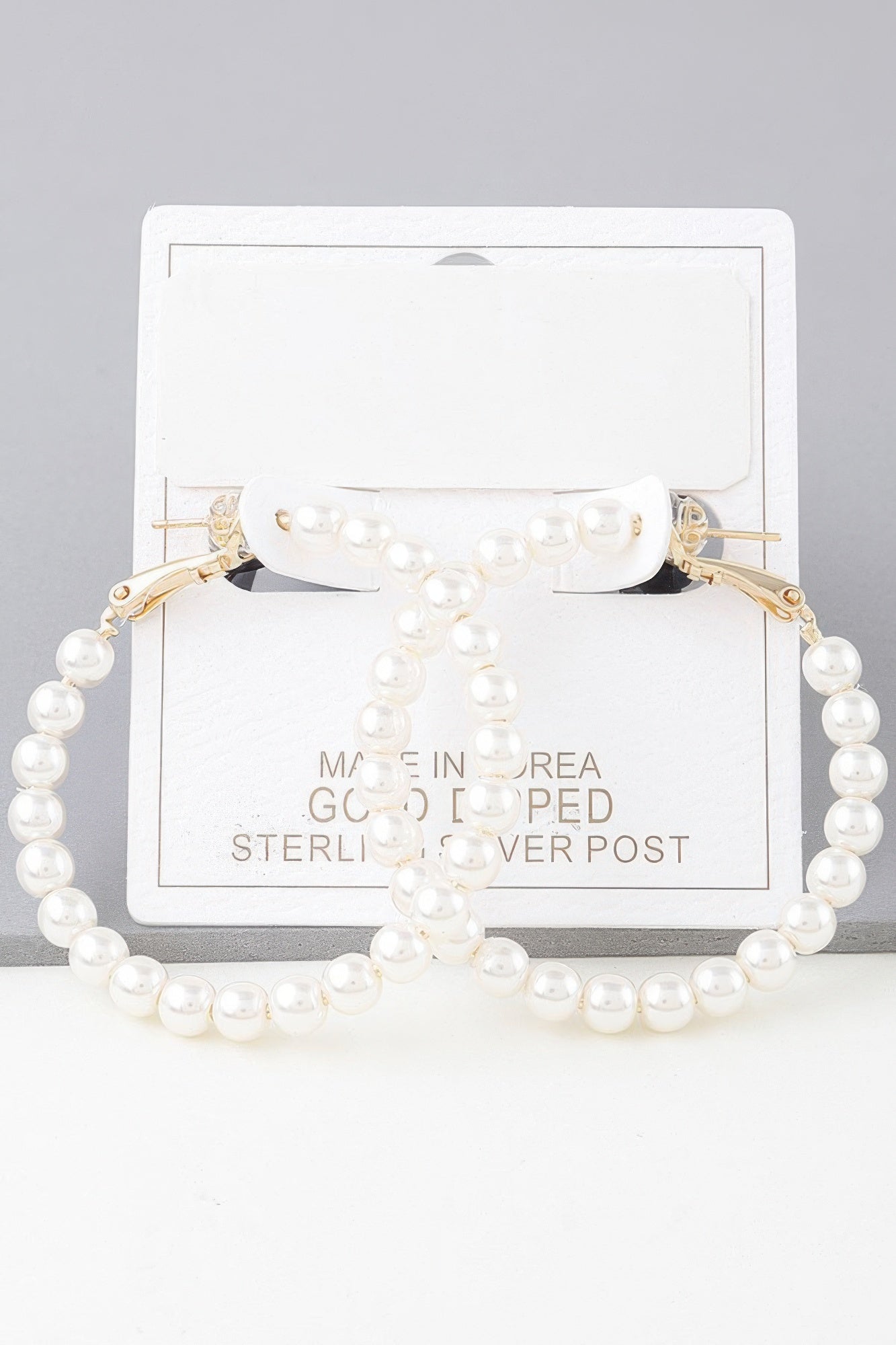 Pearl hoop earrings with gold-tone hooks and cream pearls