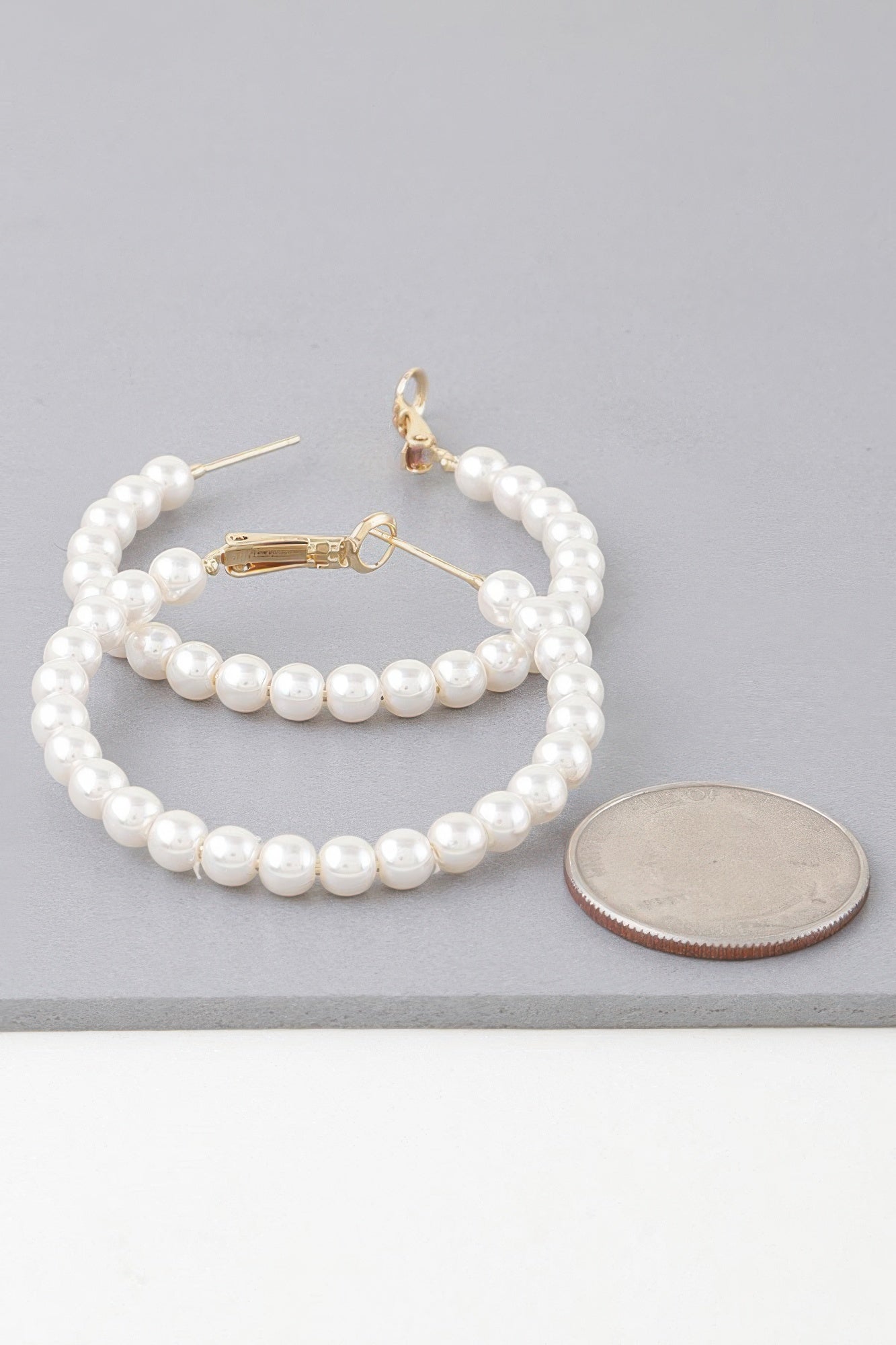 Pair of cream pearl hoop earrings with gold-tone hinges and matching bead strands