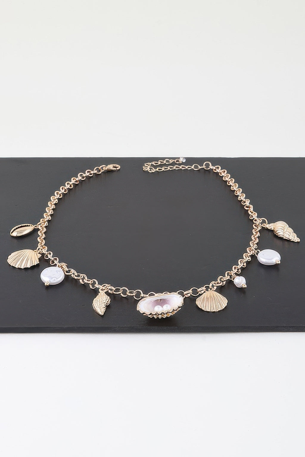 Gold pearl and shell charm necklace with multiple shell and white pearl dangles