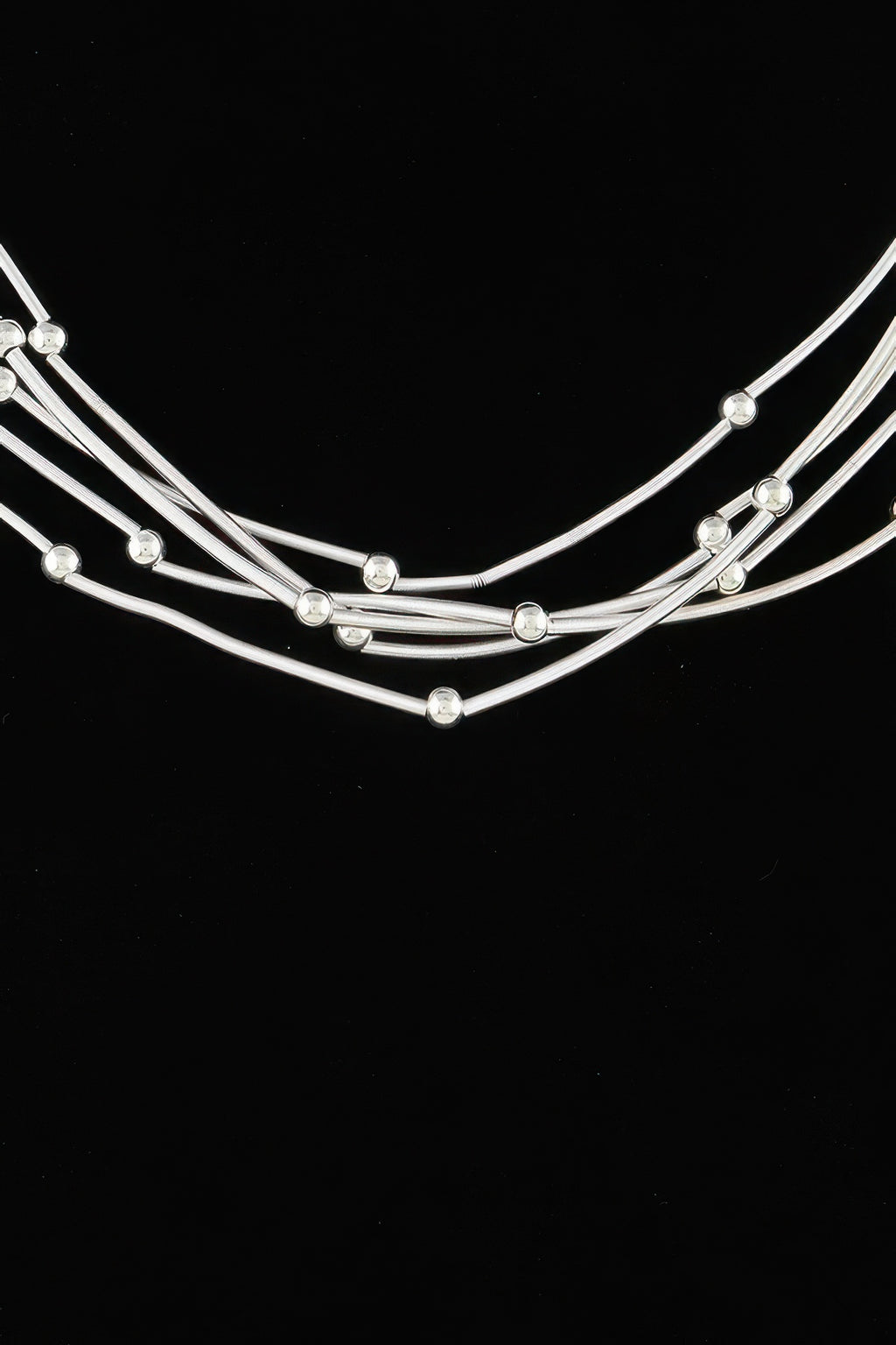 Silver-tone multi pillar beaded necklace close-up, curved strands with round bead drops