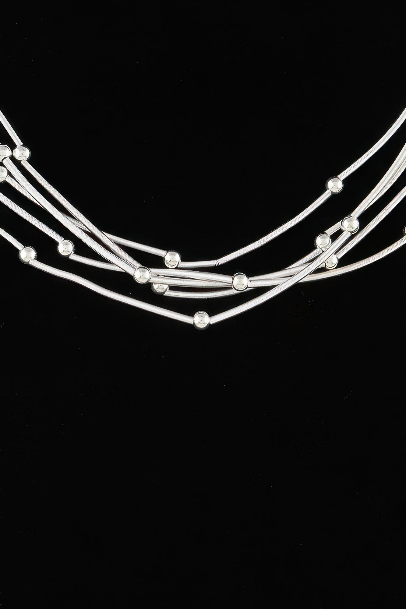 Silver-tone multi pillar beaded necklace close-up, curved strands with round bead drops