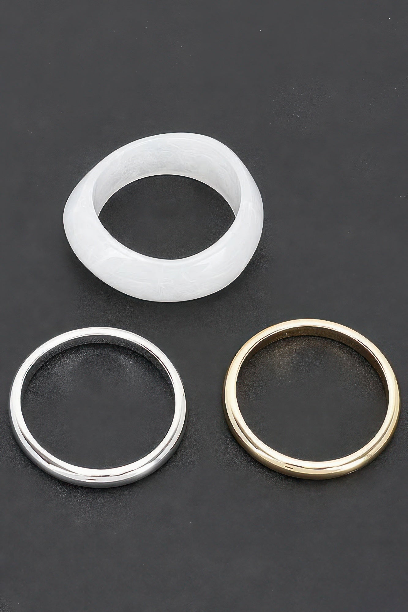 Set aus drei Armreifen: weißer, silberner und goldfarbener Resin-Bangle