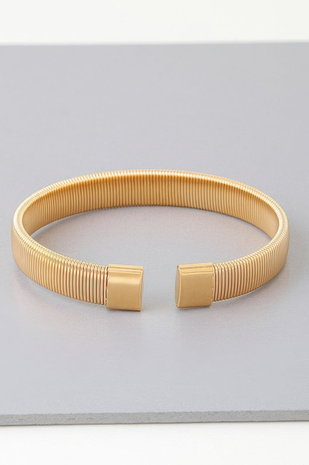 Gold multi-rib cuff bracelet, front view of square clasp detailing