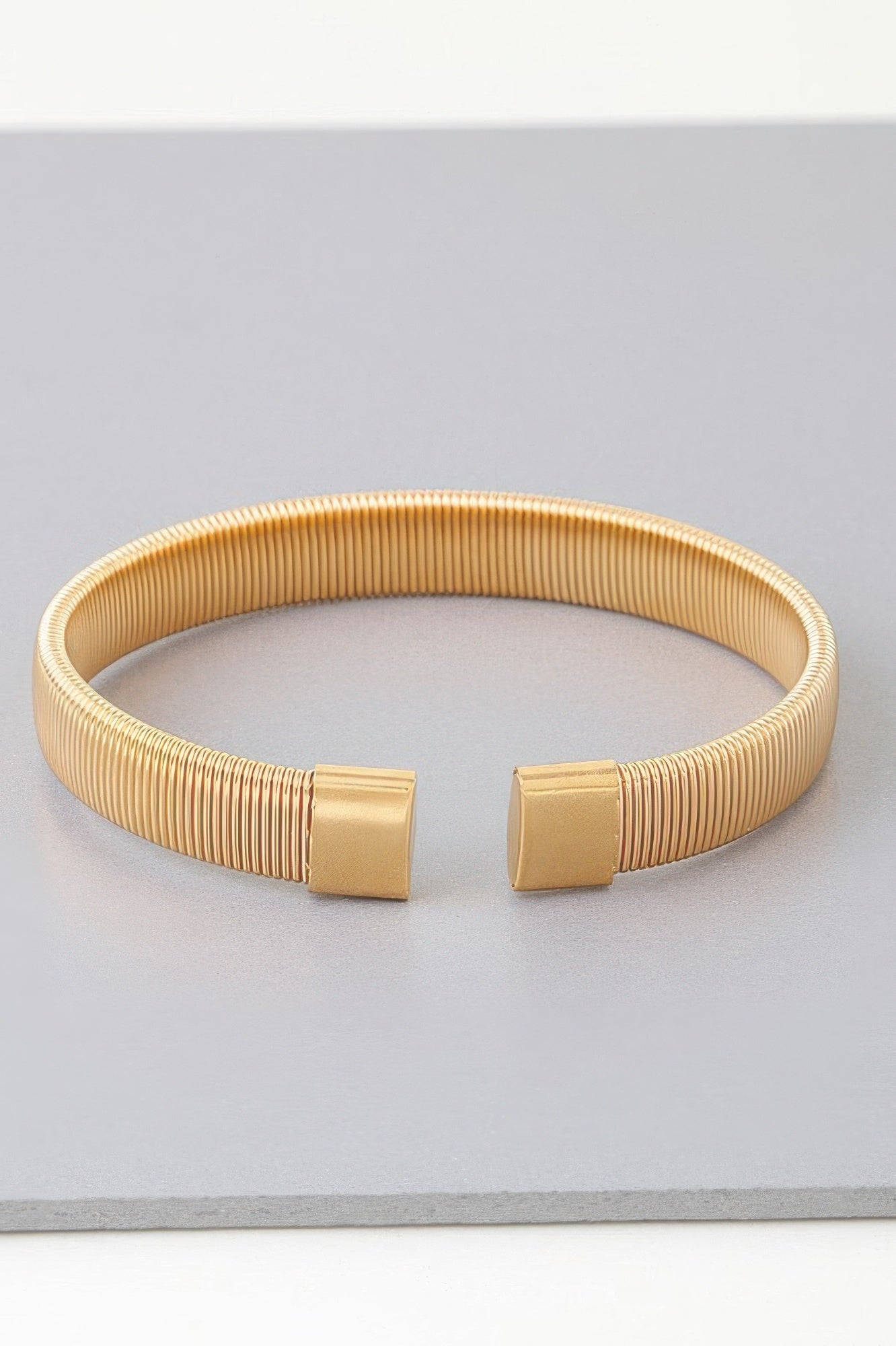 Gold multi-rib cuff bracelet, front view of square clasp detailing