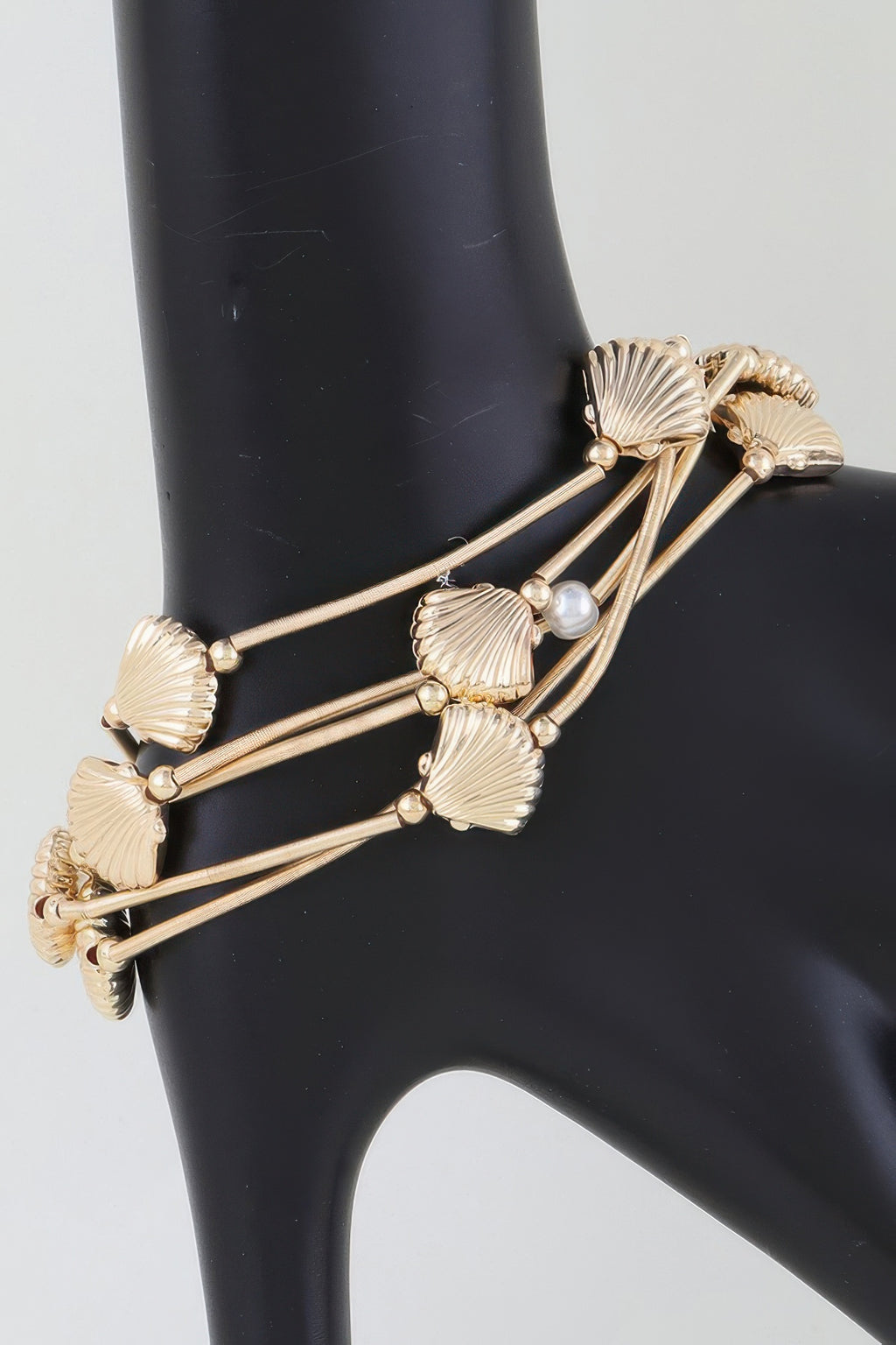 Gold multi-coil seashell bracelet with pearl beads and ribbed shell charms