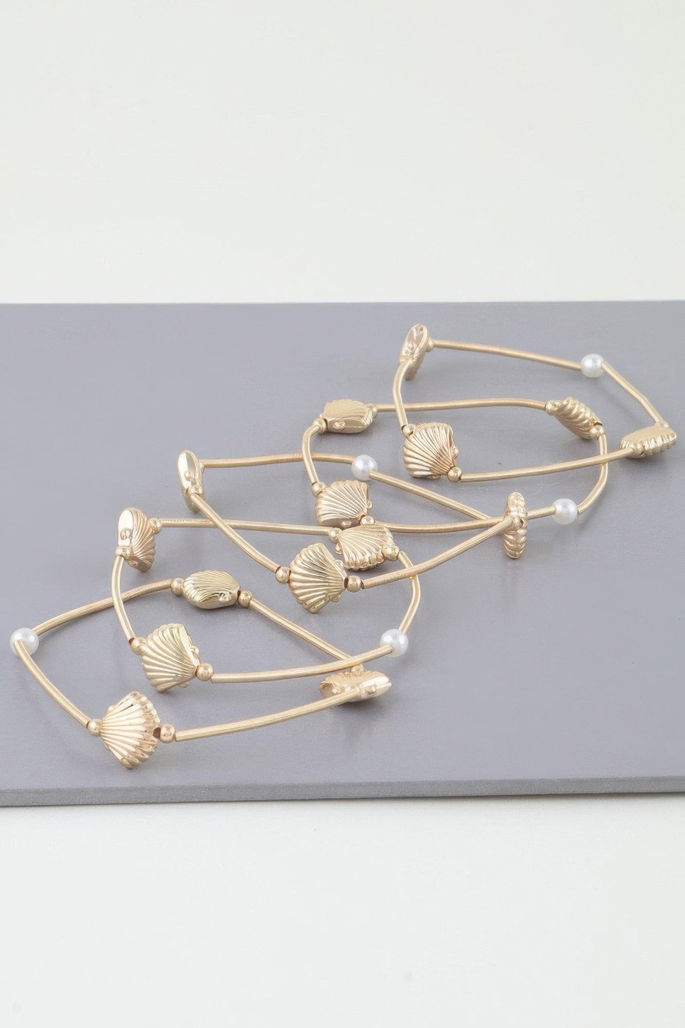 Silver multi-coil seashell bracelet with pearl beads and ribbed shell charms