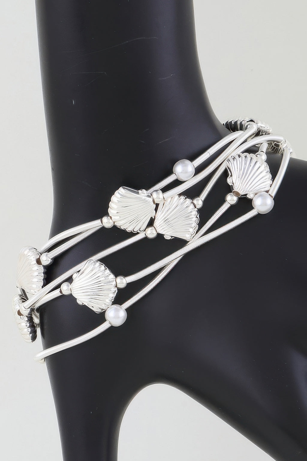 Silver-toned multi-coil bracelet with large seashell charms and pearl beads