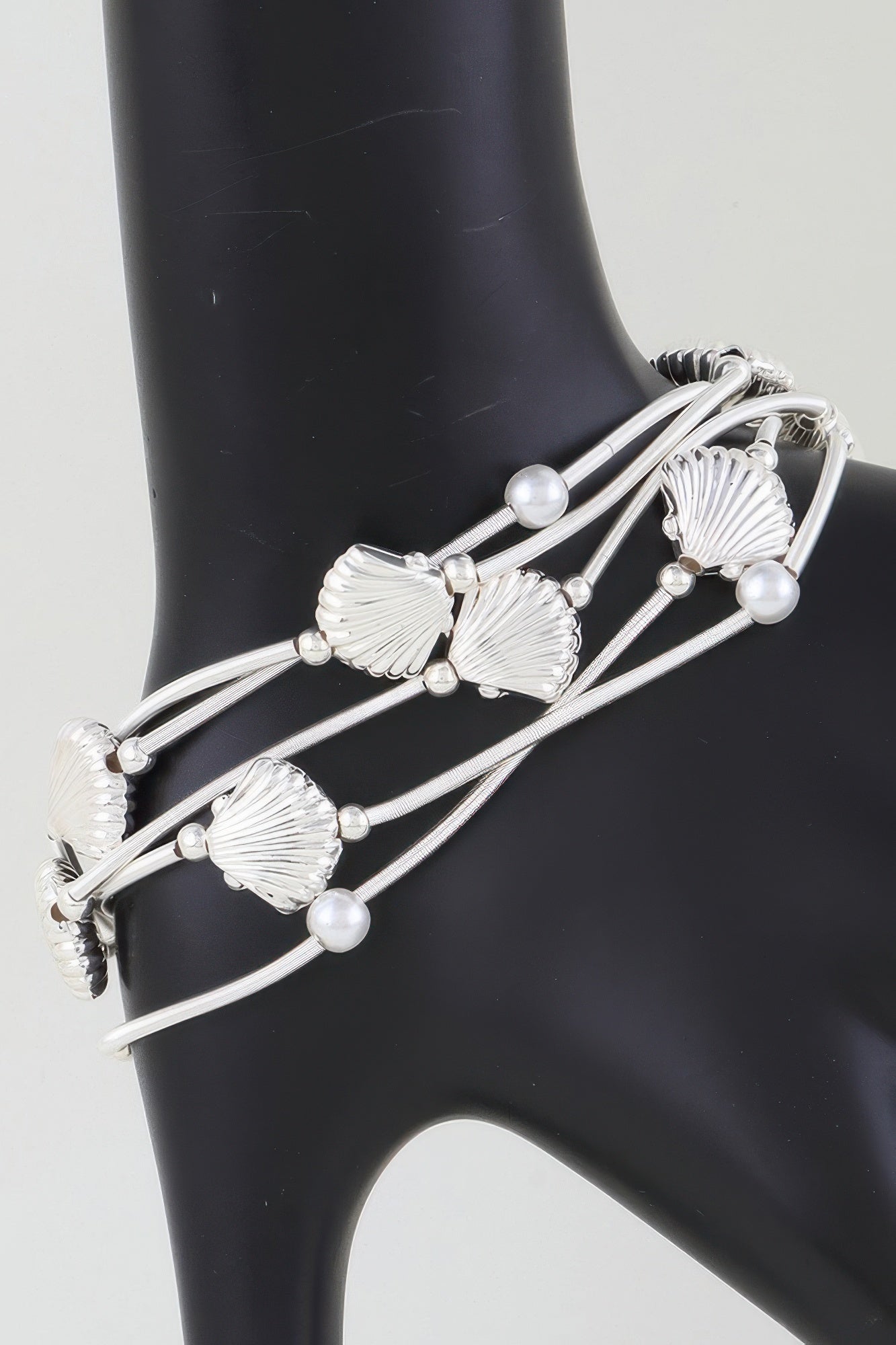 Silver-toned multi-coil bracelet with large seashell charms and pearl beads