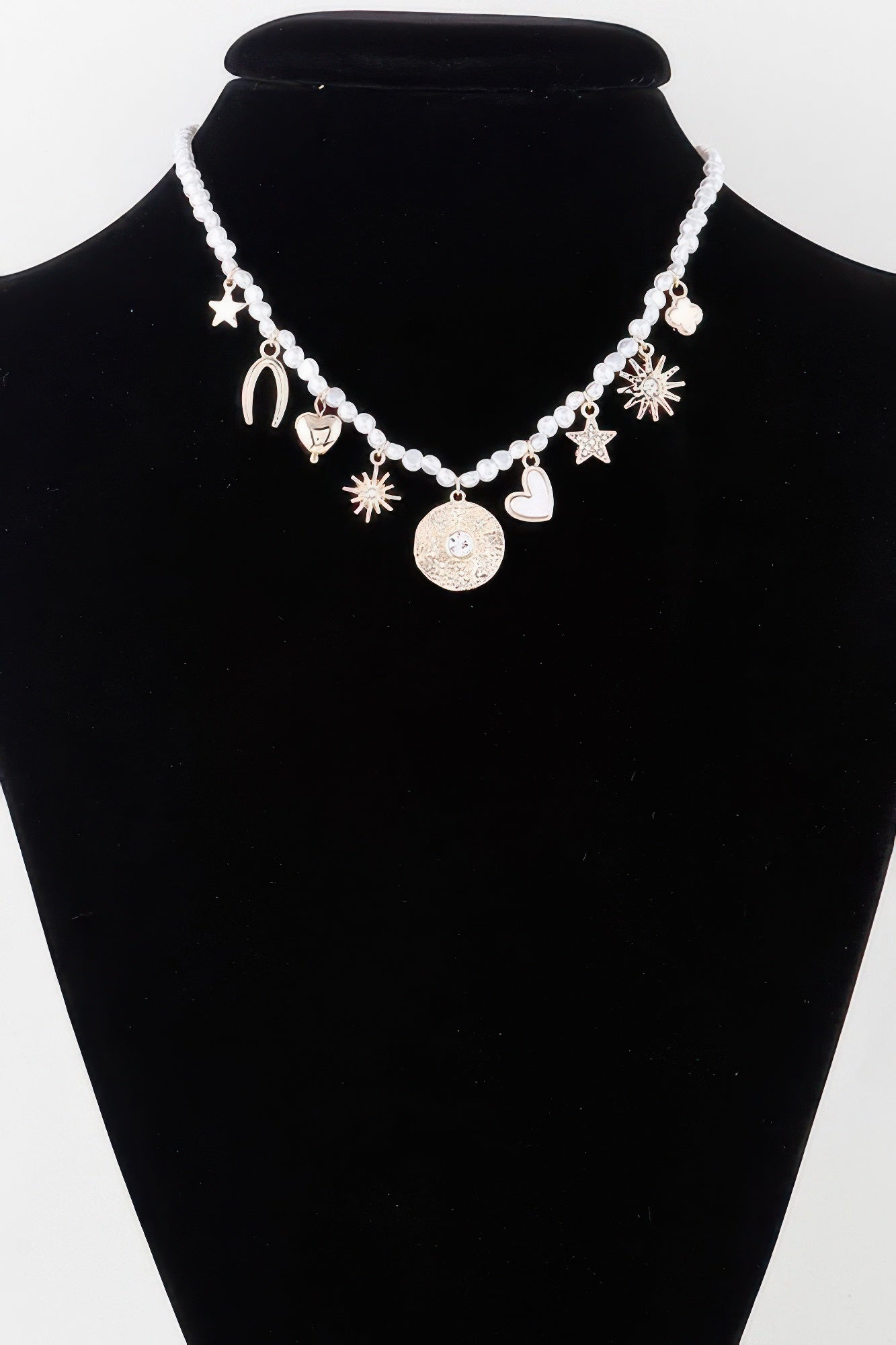 Beaded necklace with shiny charms: stars, hearts, moons and sunburst dangles