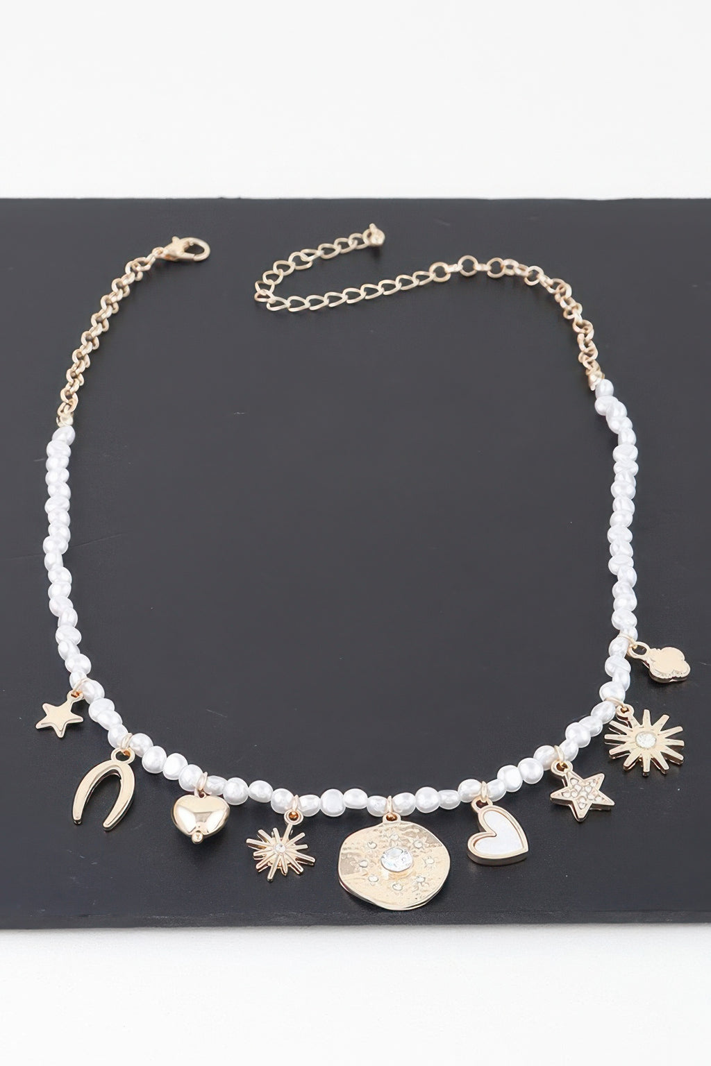 Beaded necklace featuring gold-tone charms: crescent moons, stars, hearts and coin charm