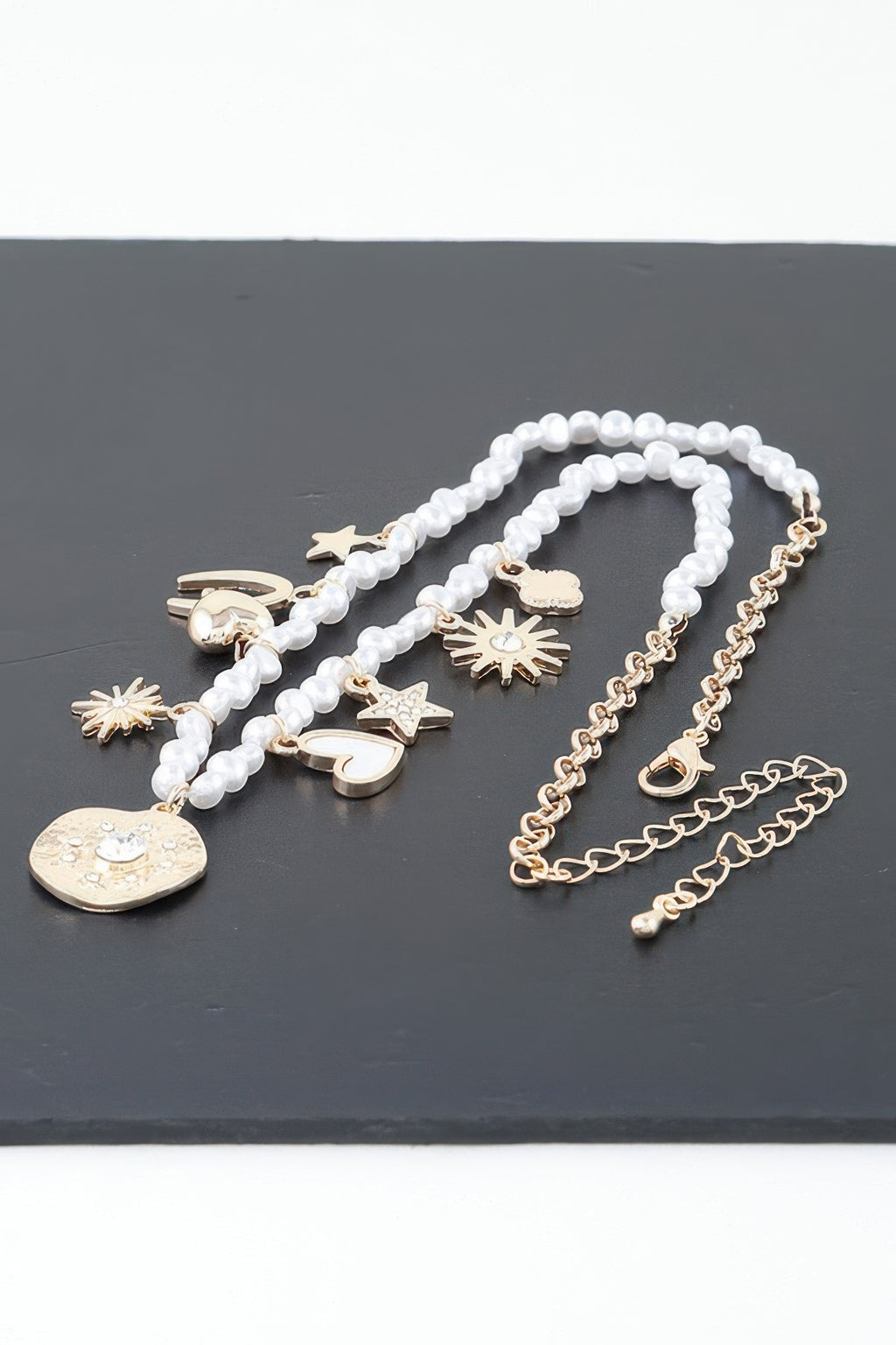 Multi-strand beaded necklace with coin, heart, star and sunburst pendants
