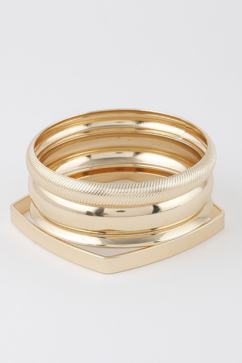 Gold multi-layer bracelet set with smooth and ridged bangles, geometric base
