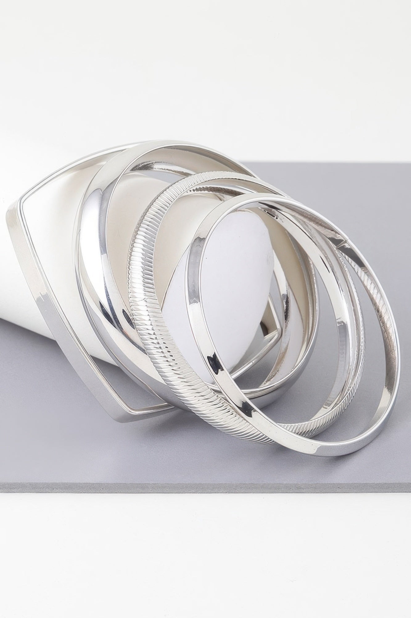 Shiny silver multi-layer bracelet with ridged cuff and curved bangles