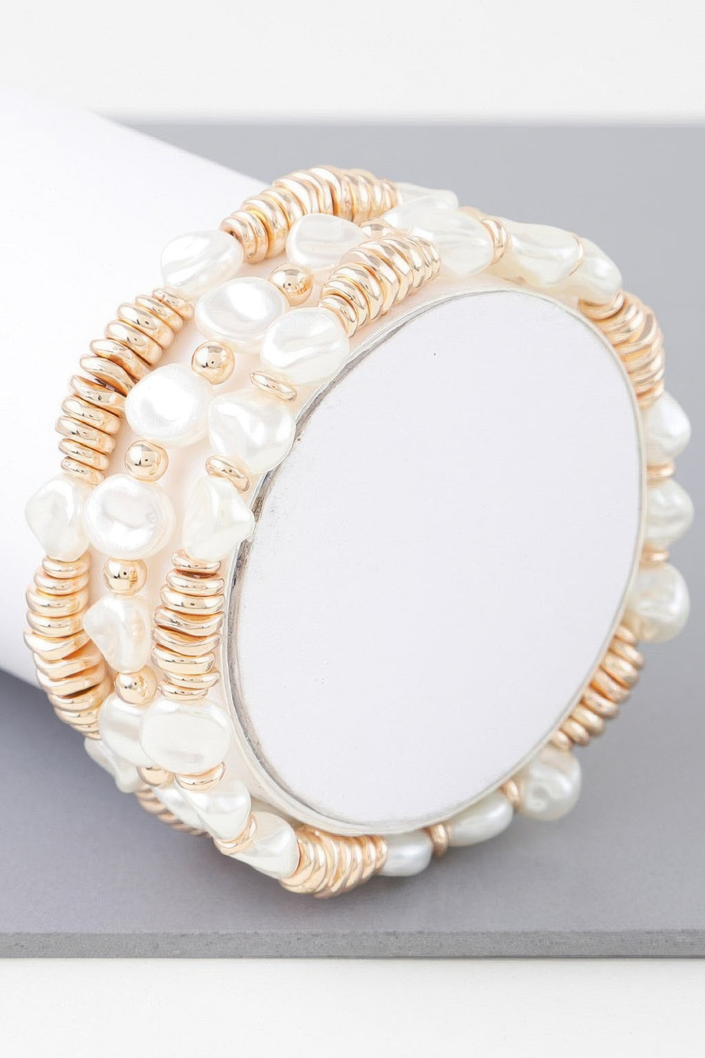 Gold-cream beaded bracelet with white pearl discs and central oval