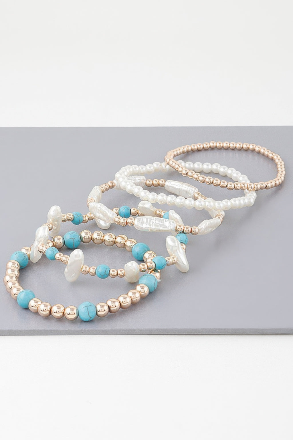 Multi-strand bracelet with pearl beads, turquoise beads, gold-tone round spacers
