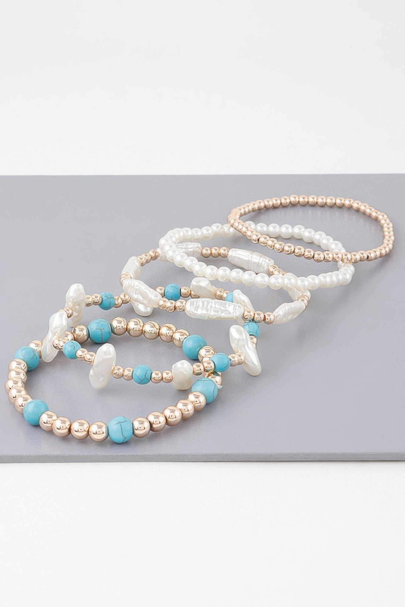Multi-strand bracelet with pearl beads, turquoise beads, gold-tone round spacers