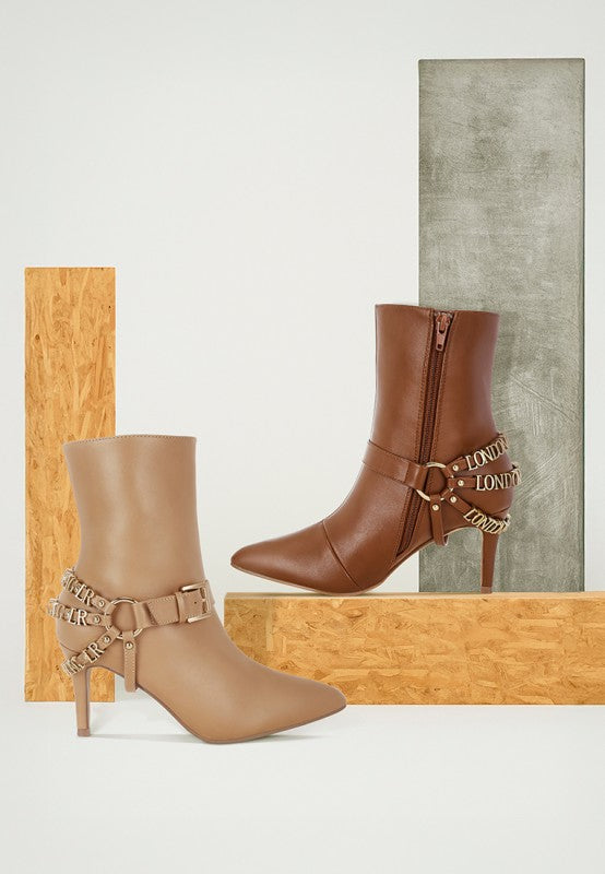 Beige stiletto ankle boot with harness straps and metal “LONDON” buckle detail