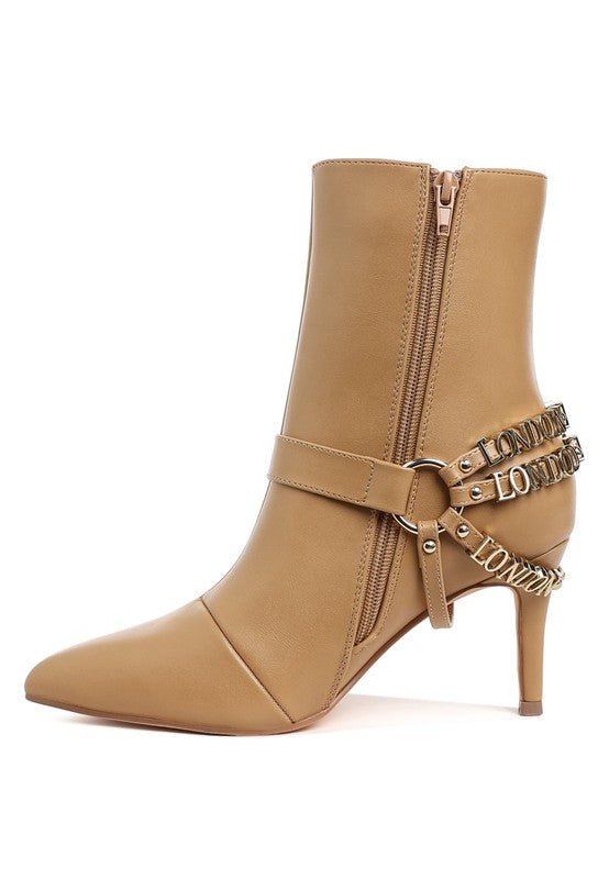 Tan stiletto ankle boot with side zipper and layered “LONDON” harness strap detail