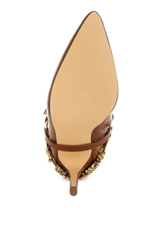 Light tan stiletto boot sole view with harness hardware near opening