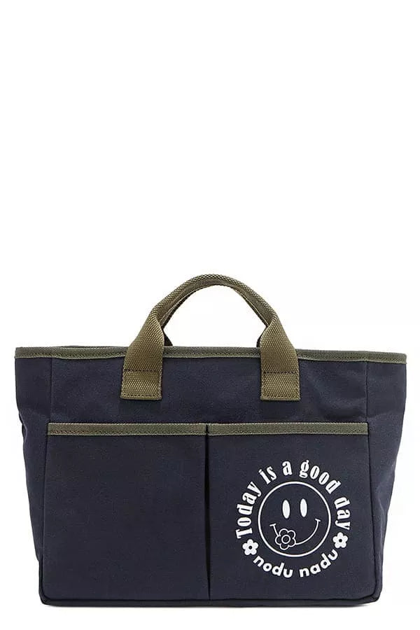 Navy canvas tote bag with olive handles, front pocket, and smiling graphic logo