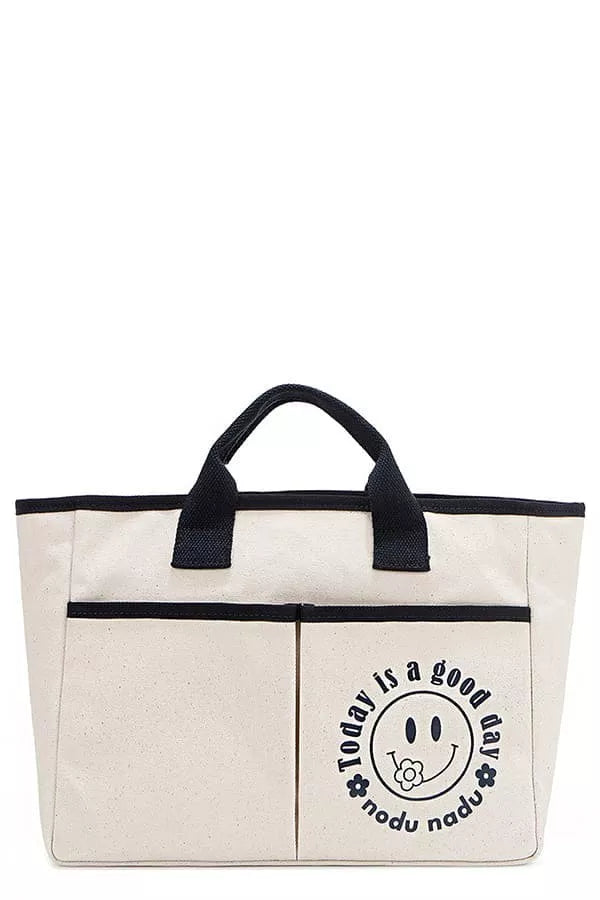 Beige canvas tote bag with black handles and round smiley graphic logo