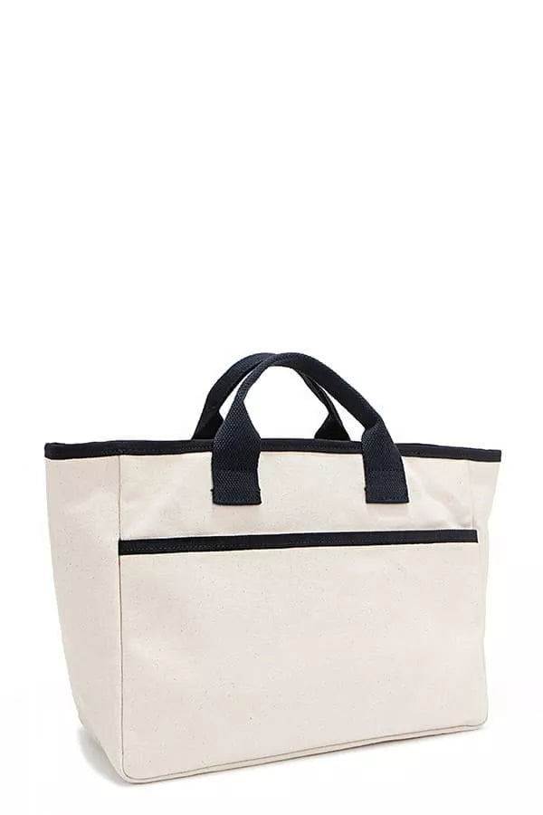 Beige canvas tote bag with navy handles and front pocket stripe