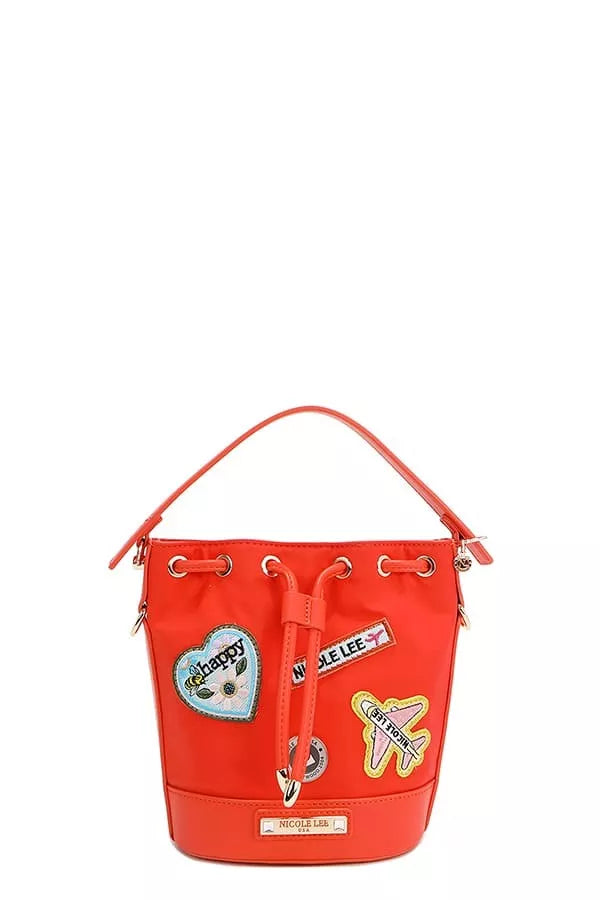 Red bucket bag with drawstring cinch and embroidered patches on the front panel