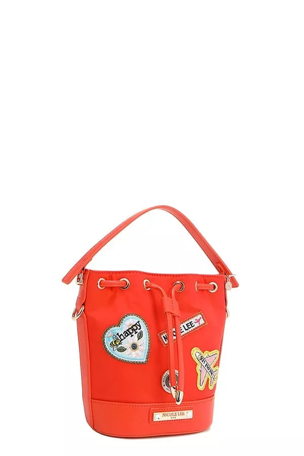 Red bucket bag side view with top handle, grommet pulls, and colorful appliqué patches