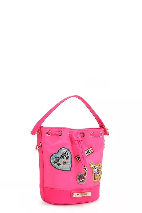 Side view of bright pink bucket bag with hanging charm details and patches
