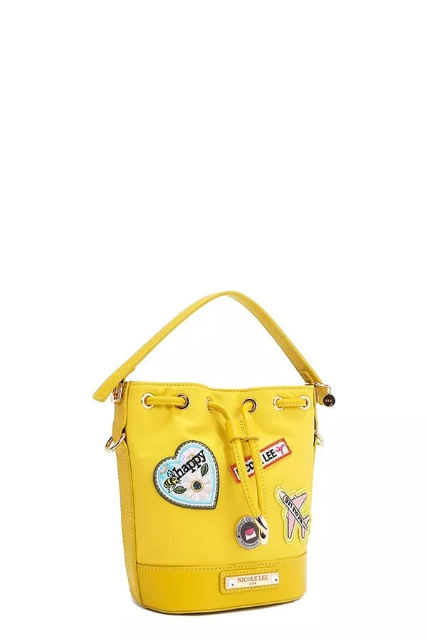 Yellow bucket bag side view with hanging charms and patch details