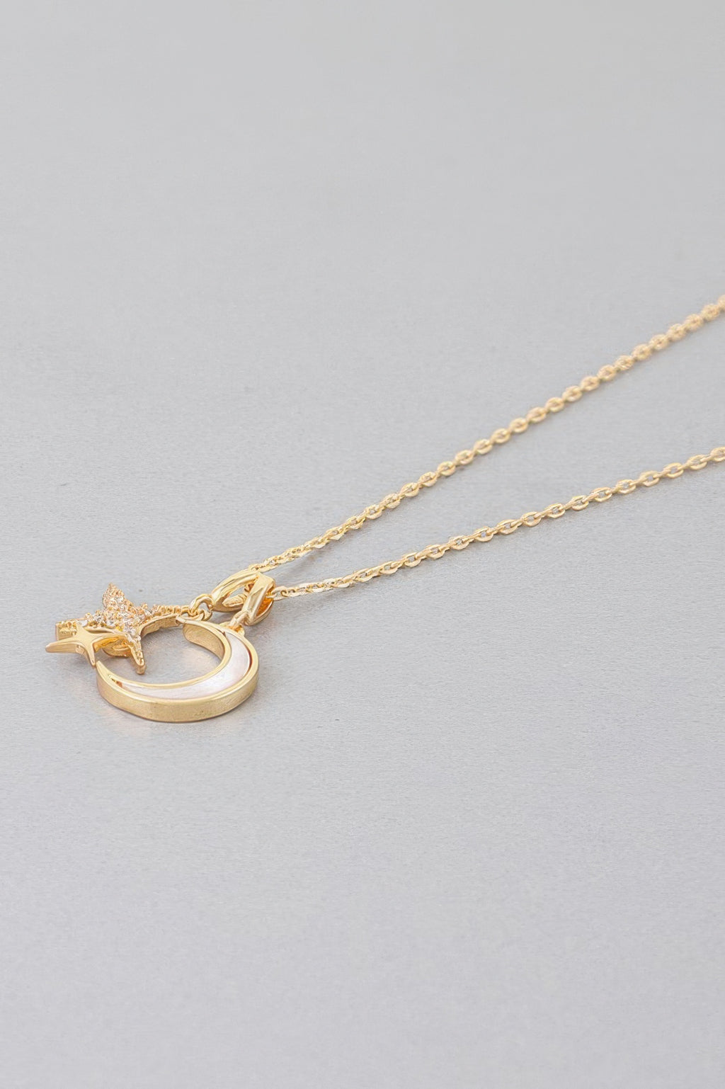 Gold chain necklace with moon-and-star charm pendant
