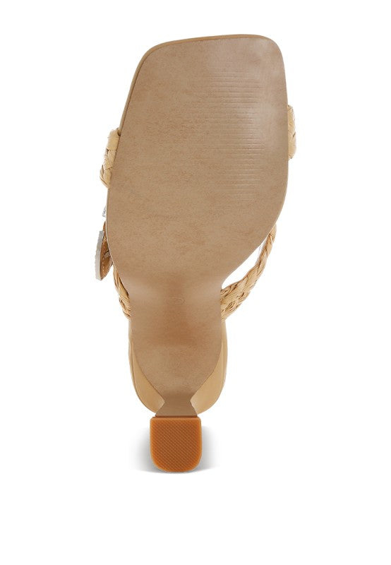 Beige sandal heel view with woven braided sides and silver-toned strap accent