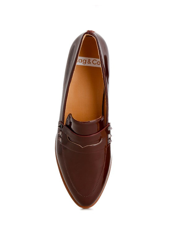 Deep brown patent pleather penny loafers, front view with closed almond toe and strap