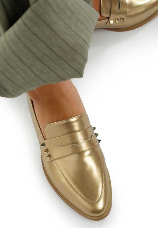 Gold patent pleather penny loafers close-up of studded strap and toe seam