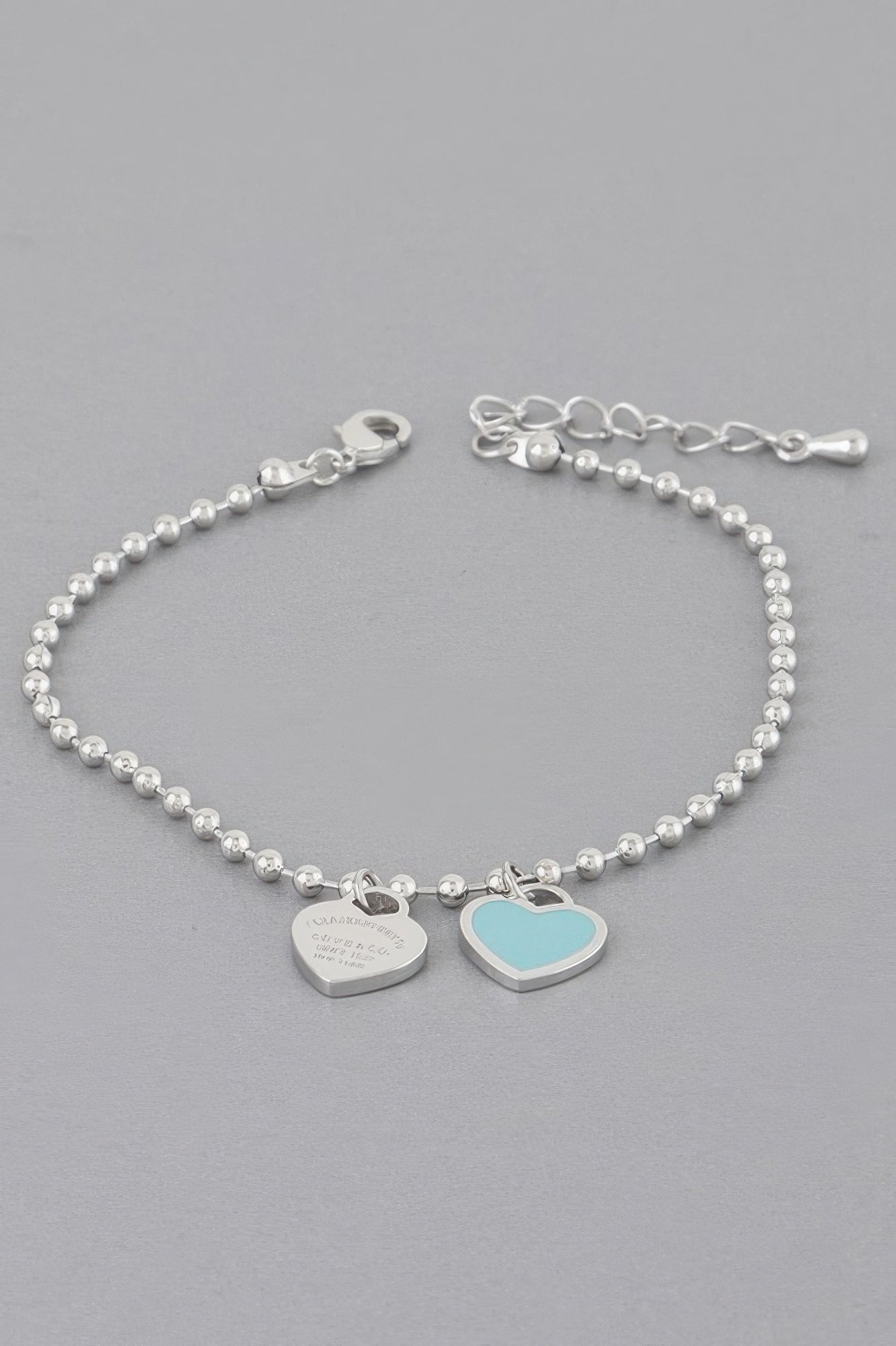 Love bracelet mit silberner Perlenkette und Herzanhängern: blaues Herz und silbernes Herzplättchen