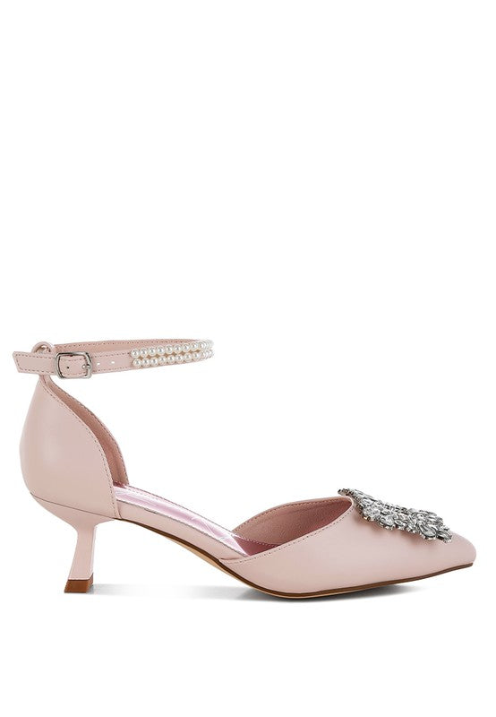 Pink kitten-heel sandal side view with jeweled brooch strap and ankle buckle